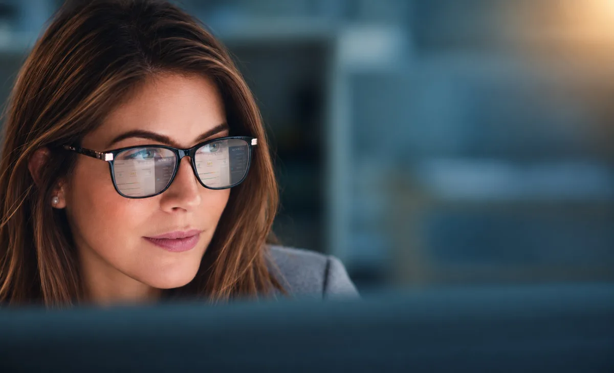 A professional focused on their screen, with a Corvia dashboard reflected in their glasses